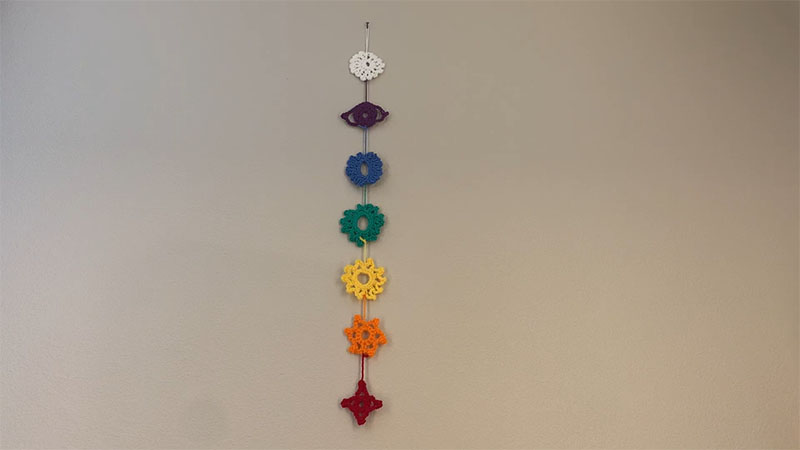 Knitted chakra rope with 7 different shapes and colors for the chakras